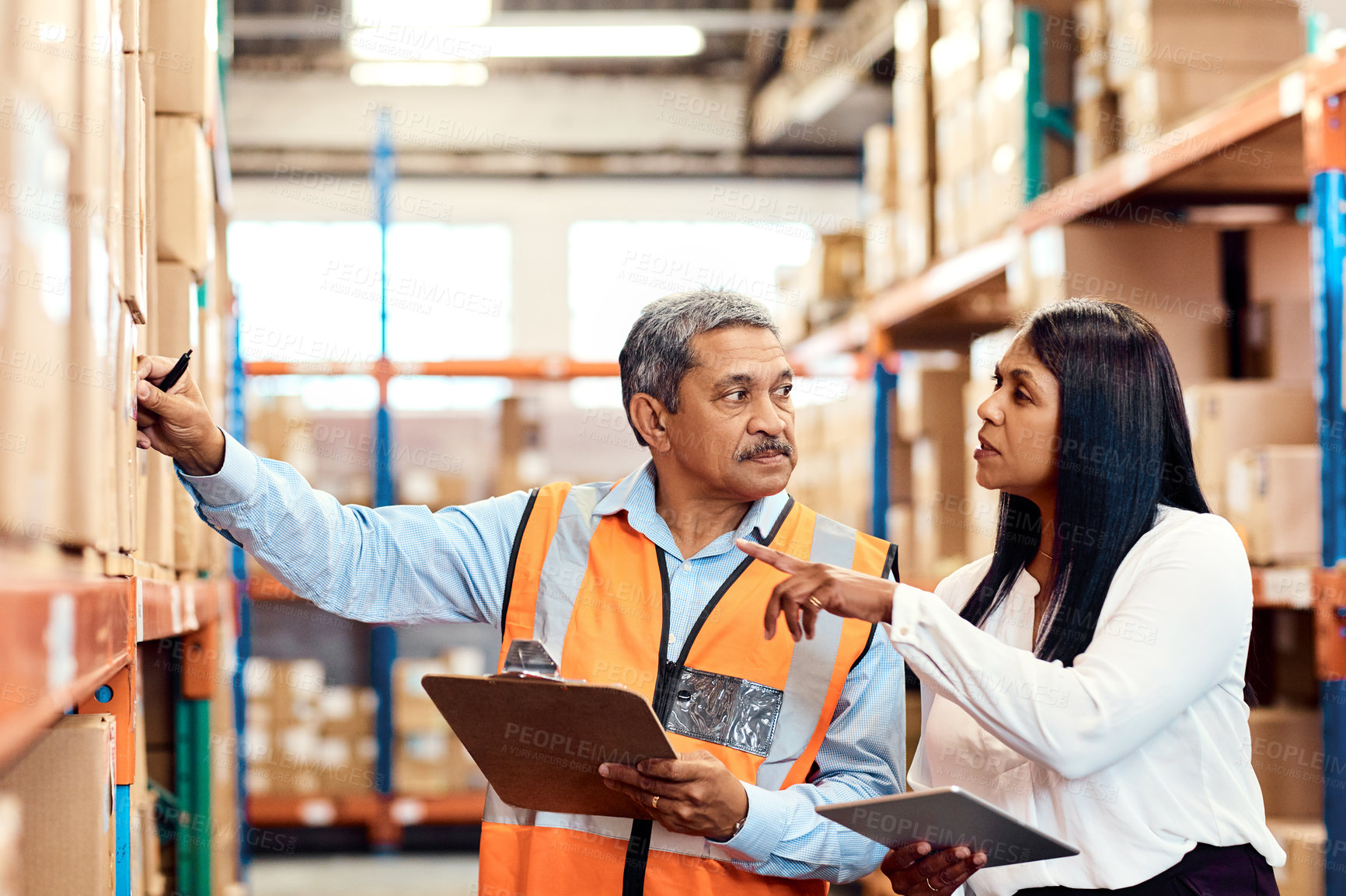 Buy stock photo Shot of a mature man and woman working together in a warehouse