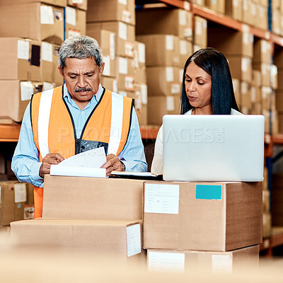 Buy stock photo Shot of a mature man and woman going through paperwork together in a warehouse