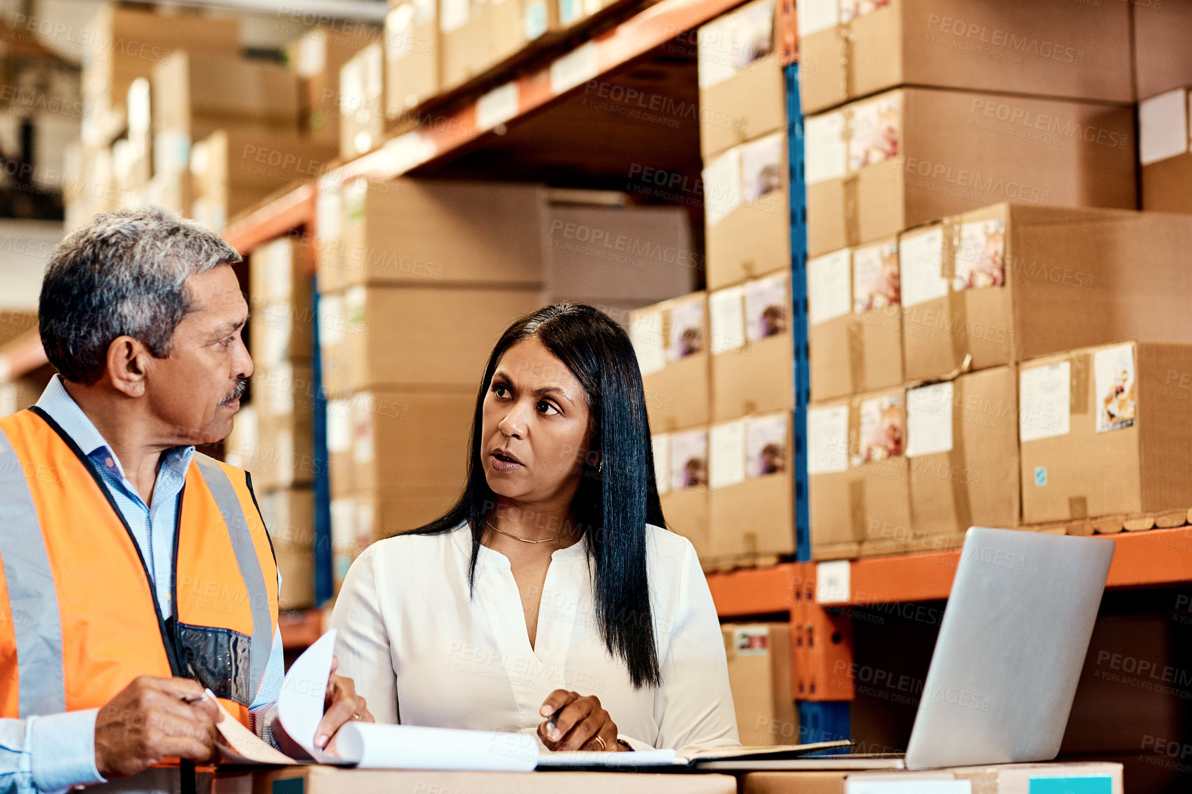 Buy stock photo Talking, clipboard and cargo with people in warehouse for delivery confirmation, shipping and laptop. Logistics, supply chain procurement and tech with mature employees for inventory checklist