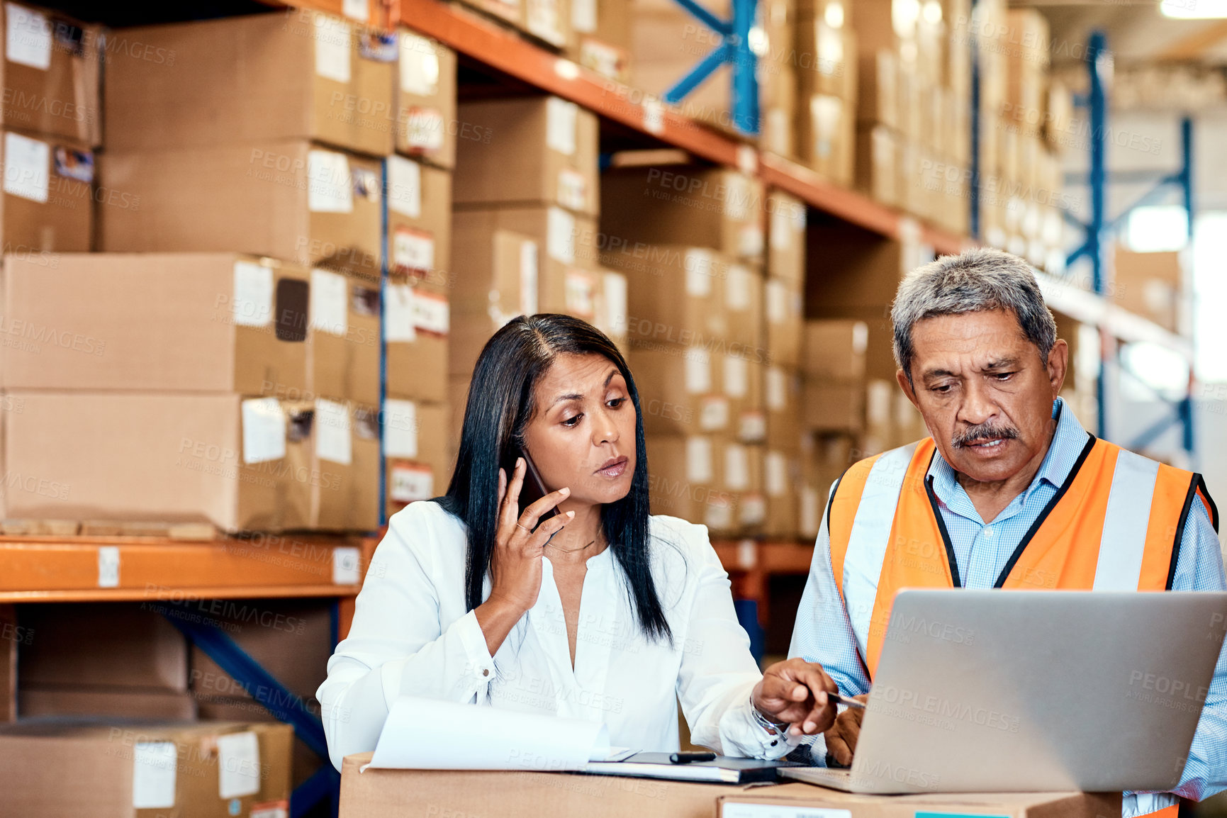 Buy stock photo Shot of a mature man and woman working together in a warehouse