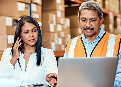 Buy stock photo Shot of a mature man and woman working together in a warehouse
