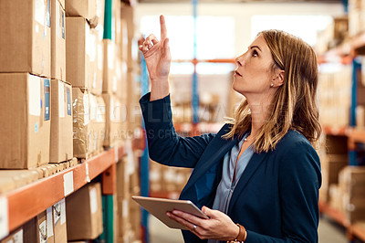 Buy stock photo Shot of a young factory manager using a digital tablet in a warehouse