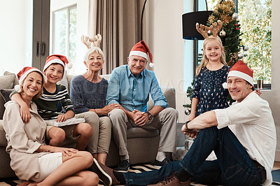 Buy stock photo Portrait of a cheerful family seated together while wearing festive hats during Christmas time