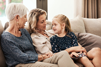 Buy stock photo Shot of a happy senior woman relaxing on the sofa with her daughter and granddaughter at home