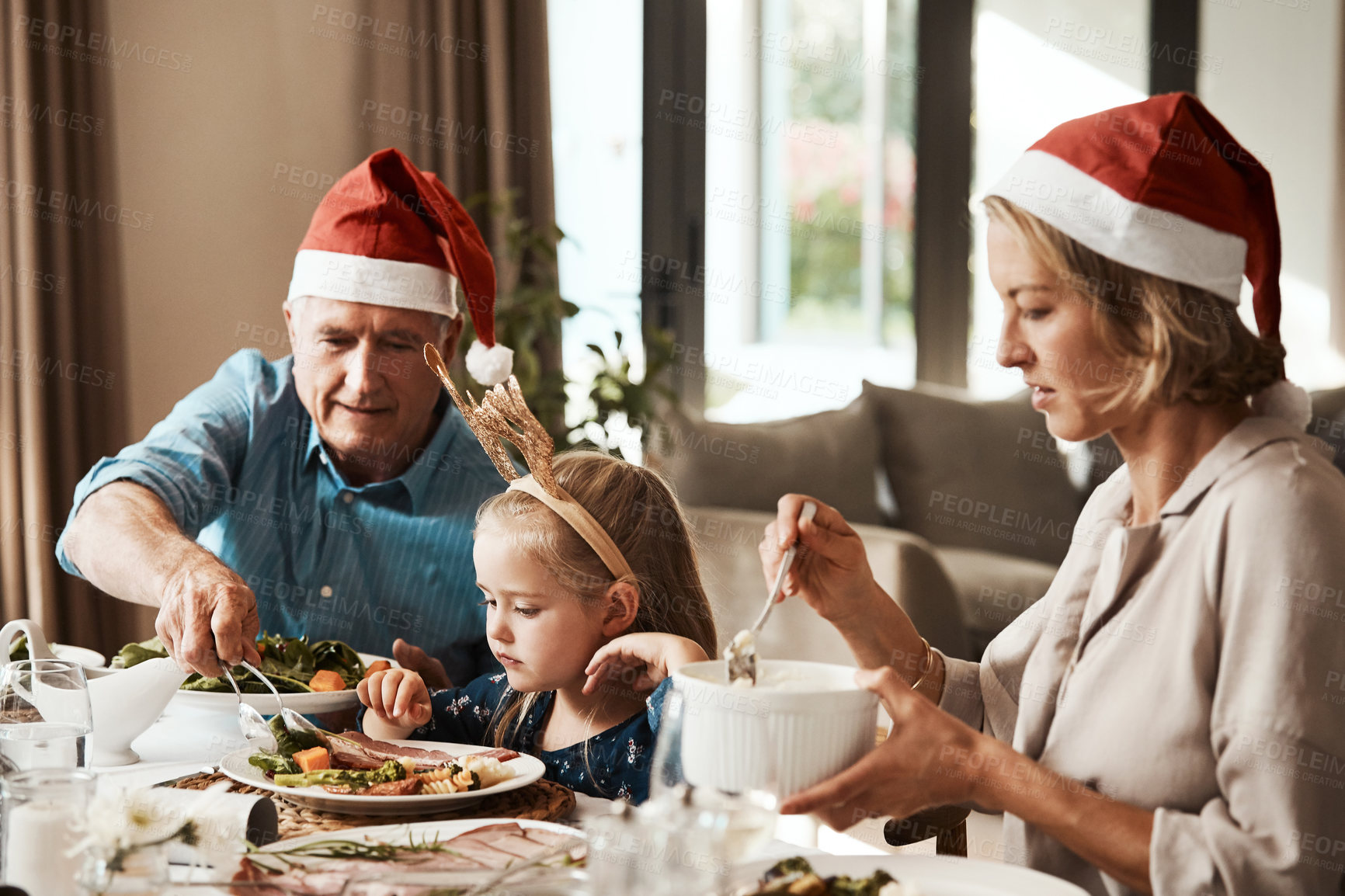 Buy stock photo Christmas, family and serving lunch with kid in home, mother and grandfather help for nutrition. Girl, parent and grandparent with xmas food on holiday celebration, growth and generations with care