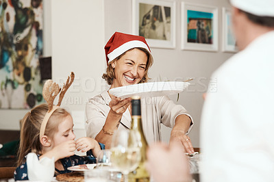 Buy stock photo Cropped shot of a family having lunch together at a table during Christmas time