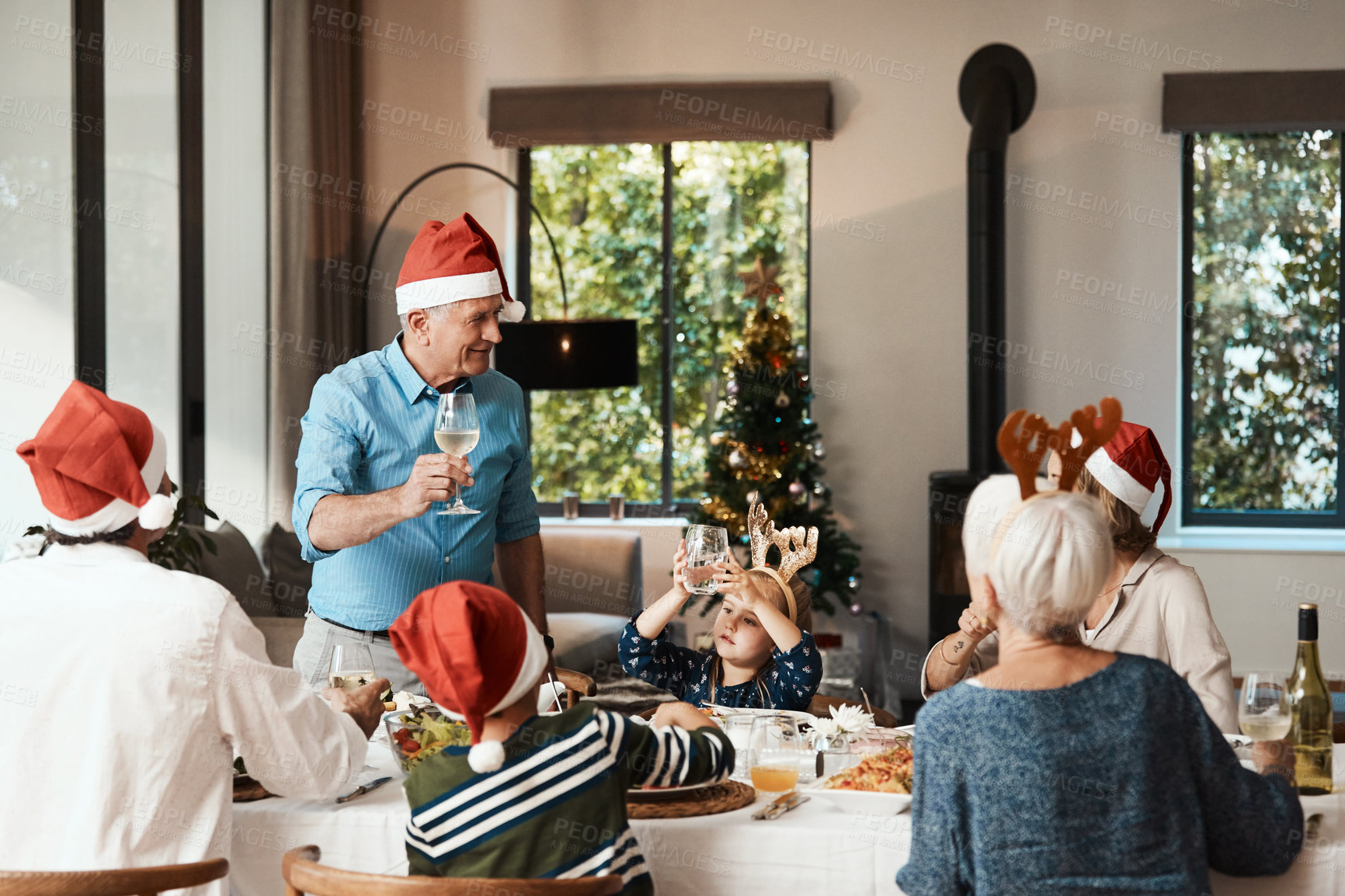 Buy stock photo Grandfather, toast and Christmas lunch with family, celebration and festive with drinks in home. Grandparents, parents and children happy for holiday gathering, dinner party and cheers with beverage