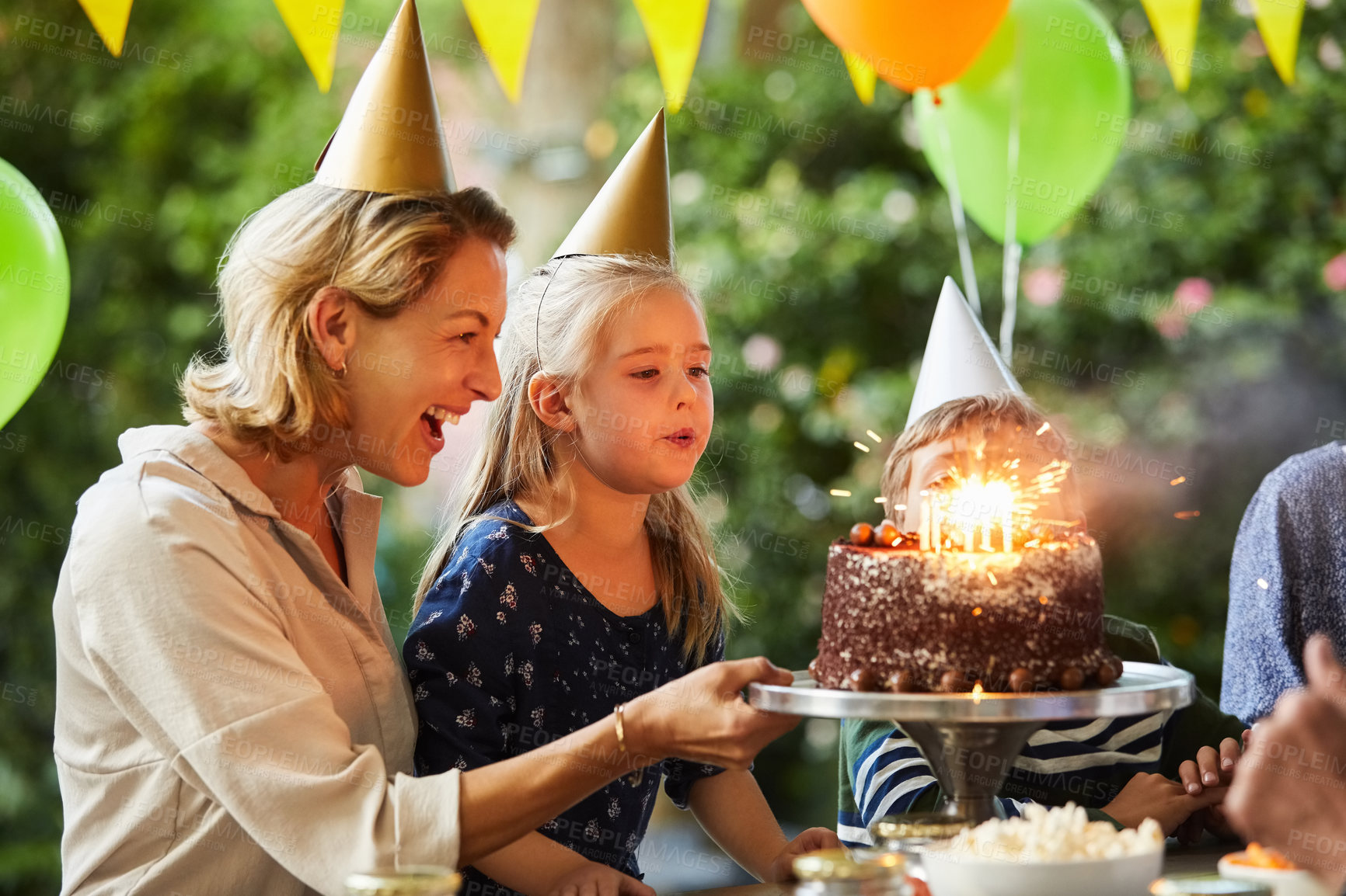 Buy stock photo Blowing, candles and children with cake, birthday party or connection with mother on break at house. Family, laugh and celebration with chocolate dessert, outdoor and happy woman with kids on event