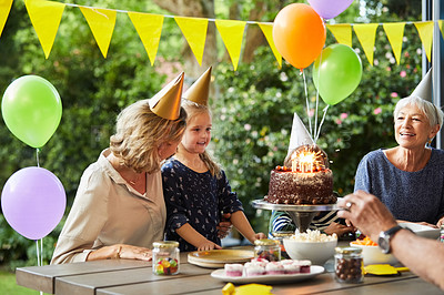 Buy stock photo Shot of a happy family celebrating a birthday at home in the garden