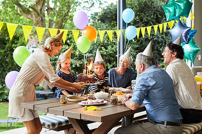 Buy stock photo Shot of a happy family celebrating a birthday at home in the garden