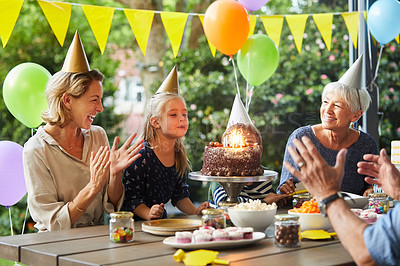 Buy stock photo Shot of a happy family celebrating a birthday at home in the garden