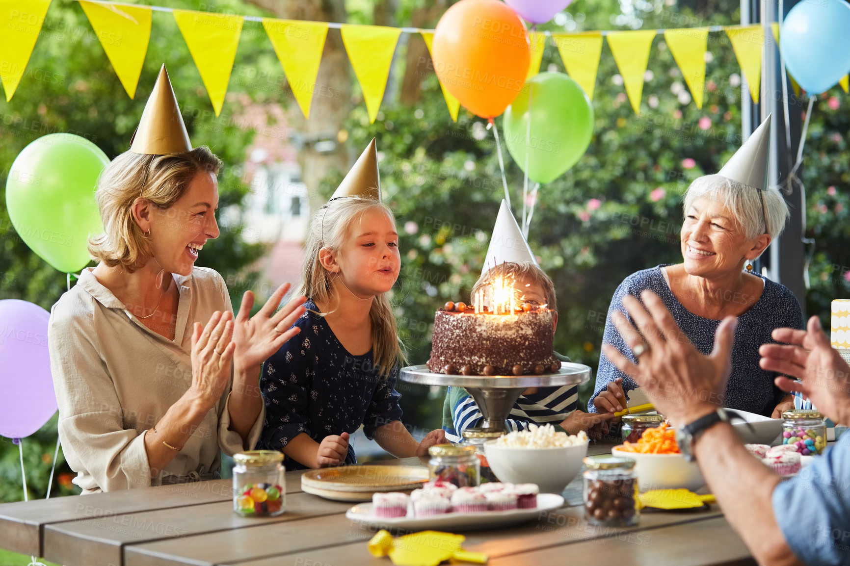 Buy stock photo Shot of a happy family celebrating a birthday at home in the garden