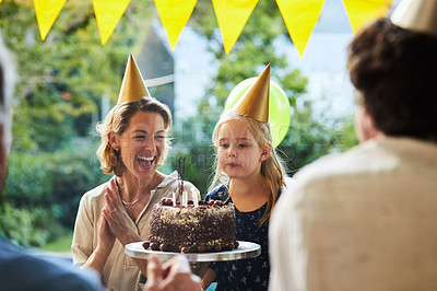 Buy stock photo Shot of a happy family celebrating a birthday at home in the garden