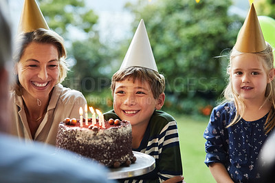 Buy stock photo Shot of a happy family celebrating a birthday at home in the garden