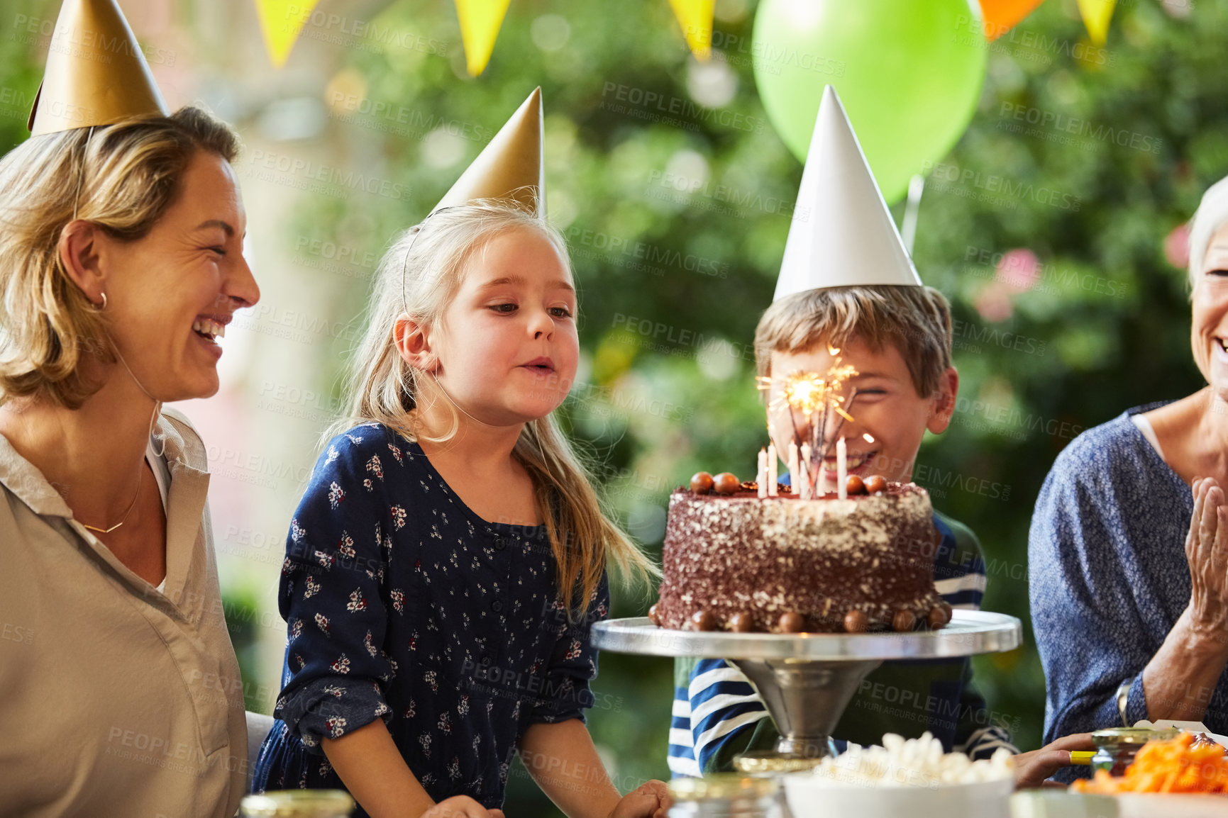 Buy stock photo Blowing, candles and children with birthday cake, party and laughing with family on break at house. Grandma, clapping and celebration with chocolate dessert, outdoor or happy women with kids at event