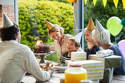 Buy stock photo Shot of a happy family celebrating a birthday at home in the garden