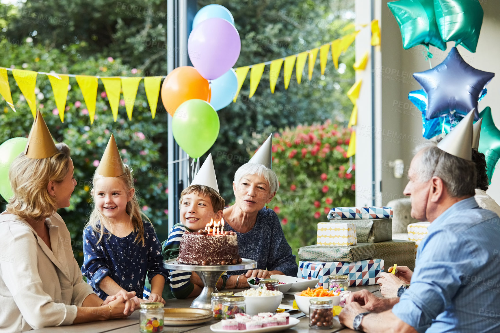 Buy stock photo Happy, family and child with birthday cake in backyard for party, event and celebrate milestone. Generations, house and kids with mom, grandparents and singing for special day, candles and dessert