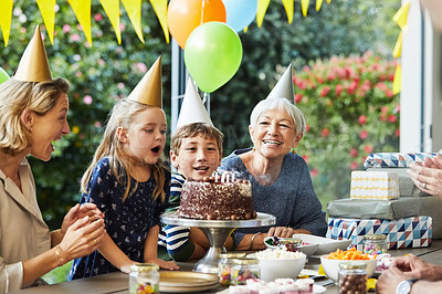 Buy stock photo Shot of a happy family celebrating a birthday at home in the garden