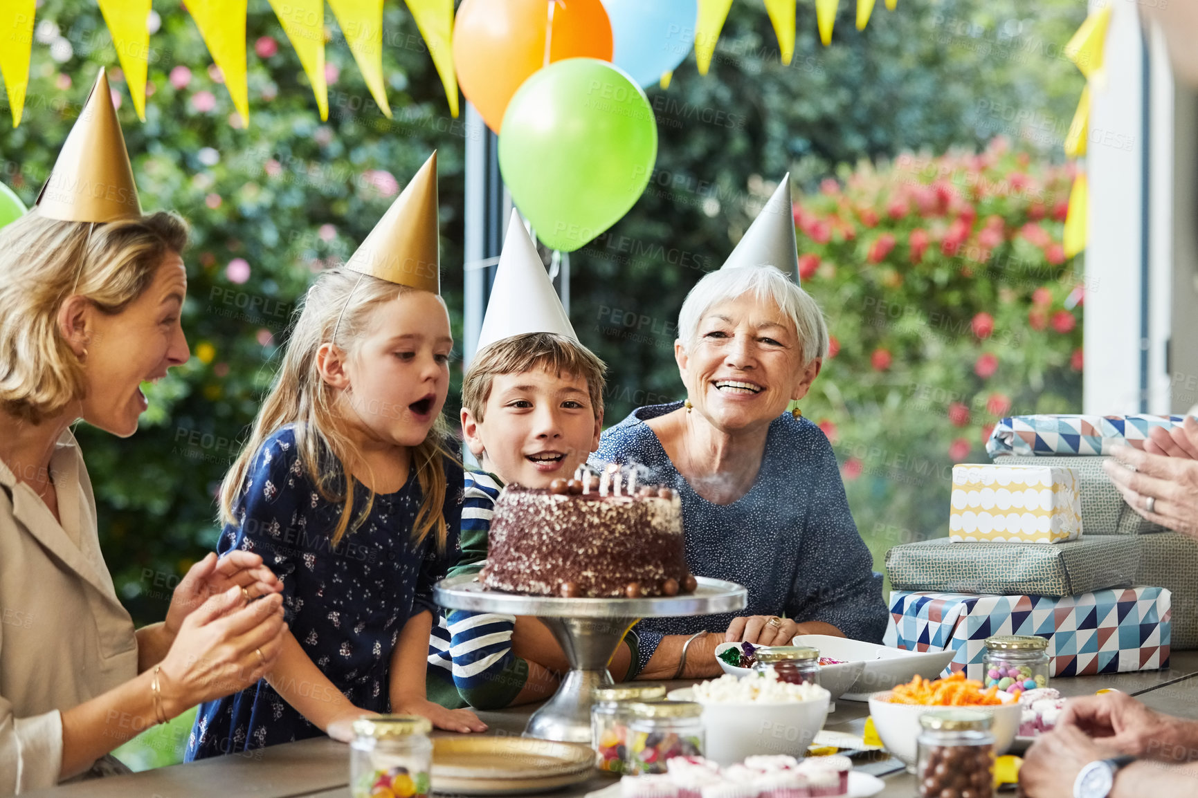 Buy stock photo Candles, family and girl with birthday cake in backyard for party, event and celebrate milestone. Excited, outdoor and kids with mom, grandparents and making wish for special day, fun and dessert