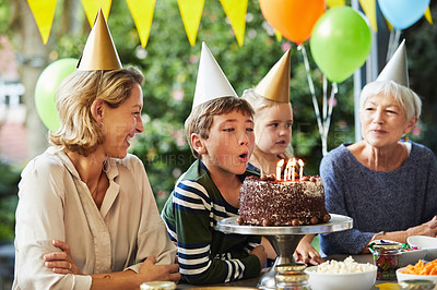 Buy stock photo Shot of a happy family celebrating a birthday at home in the garden