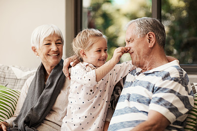 Buy stock photo Shot of an adorable little girl having fun with her grandmother and grandfather outside at home