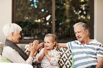 Buy stock photo Shot of an adorable little girl having fun with her grandmother and grandfather outside at home