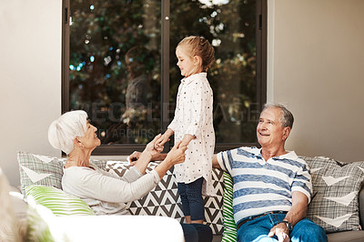 Buy stock photo Shot of an adorable little girl spending quality time with her grandmother and grandfather outside at home