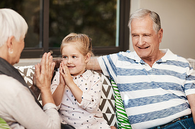 Buy stock photo Shot of an adorable little girl having fun with her grandmother and grandfather outside at home