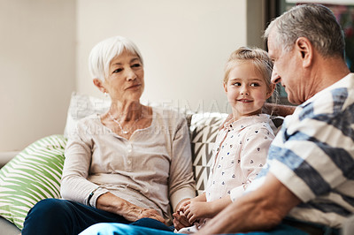 Buy stock photo Shot of an adorable little girl spending quality time with her grandmother and grandfather outside at home
