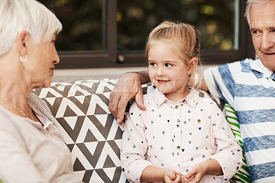 Buy stock photo Shot of an adorable little girl spending quality time with her grandmother and grandfather outside at home