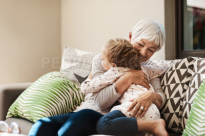 Buy stock photo Shot of a senior woman and her granddaughter hugging outside at home
