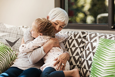 Buy stock photo Shot of a senior woman and her granddaughter hugging outside at home