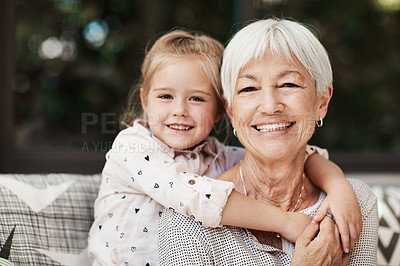 Buy stock photo Shot of a senior woman and her granddaughter playing together outside at home