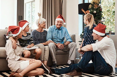 Buy stock photo Cropped shot of a cheerful family seated together while wearing festive hats during Christmas time