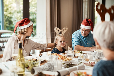Buy stock photo Cropped shot of a family having lunch together at a table during Christmas time