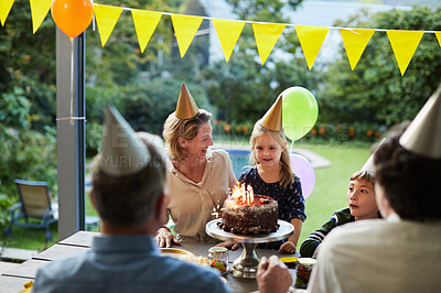 Buy stock photo Shot of a happy family celebrating a birthday at home in the garden