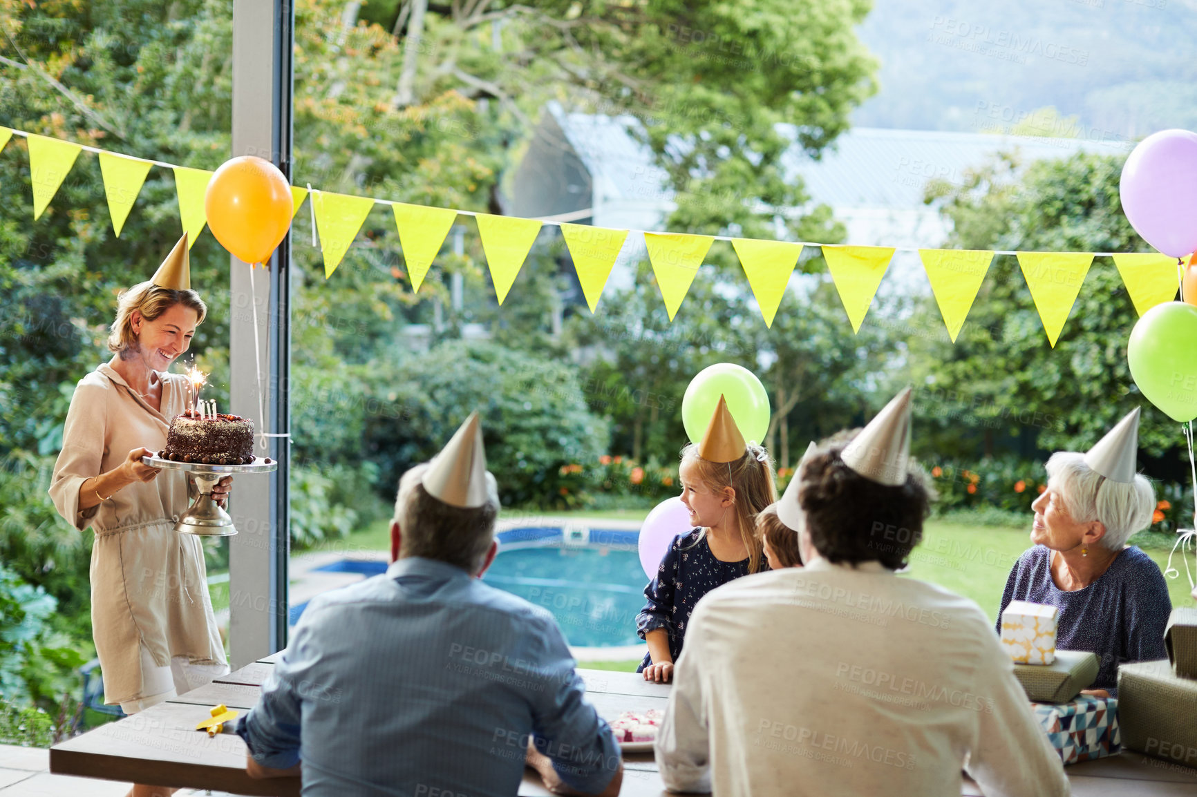 Buy stock photo Shot of a happy family celebrating a birthday at home in the garden