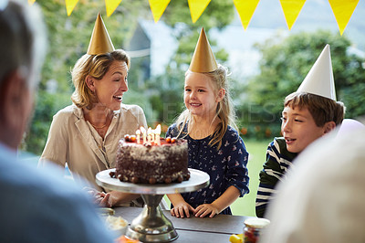 Buy stock photo Shot of a happy family celebrating a birthday at home in the garden