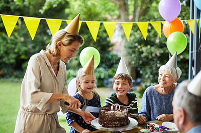 Buy stock photo Shot of a happy family celebrating a birthday at home in the garden