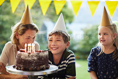 Buy stock photo Shot of a happy family celebrating a birthday at home in the garden