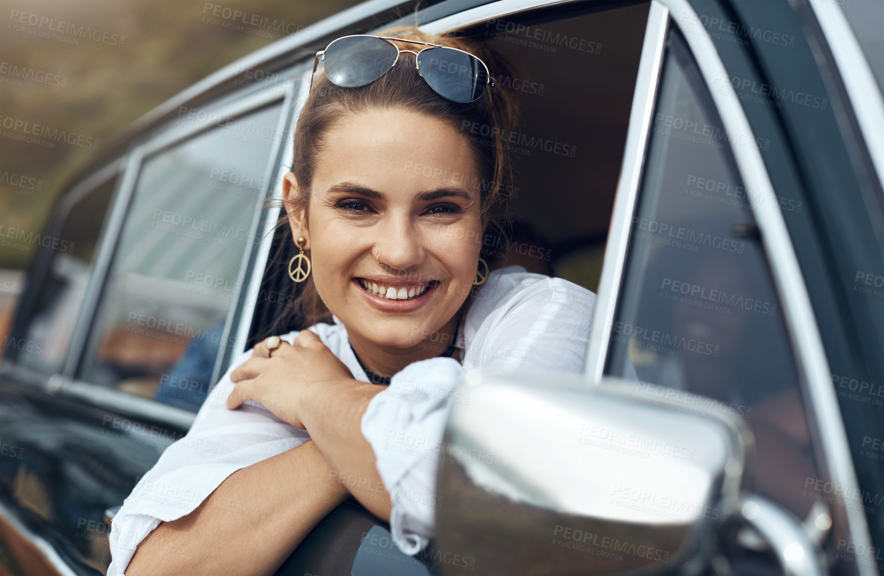 Buy stock photo Shot of a happy young woman enjoying a road trip