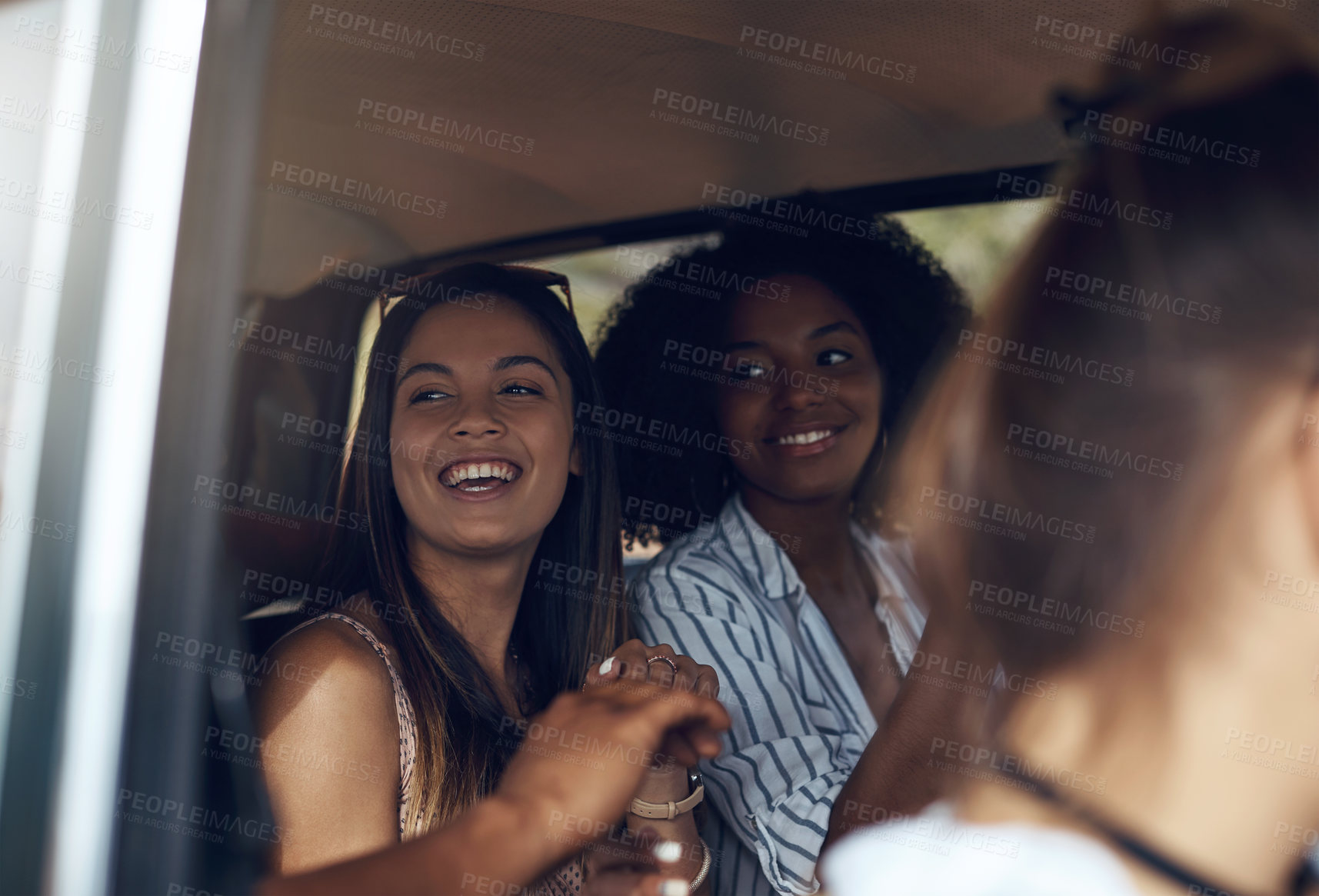 Buy stock photo Shot of a group of happy young friends going on a road trip together
