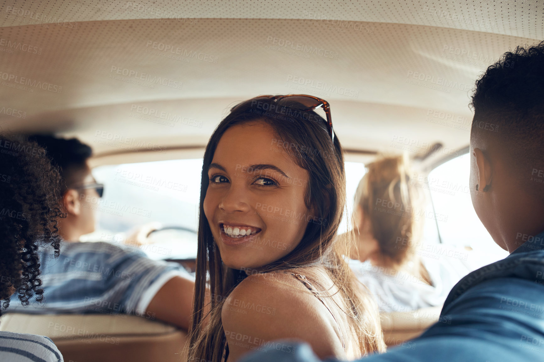 Buy stock photo Shot of a group of happy young friends going on a road trip together