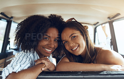 Buy stock photo Shot of two happy young friends going on a road trip together