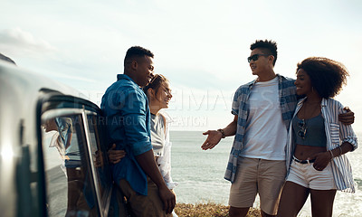 Buy stock photo Shot of a group of happy young friends enjoying a road trip along the coast