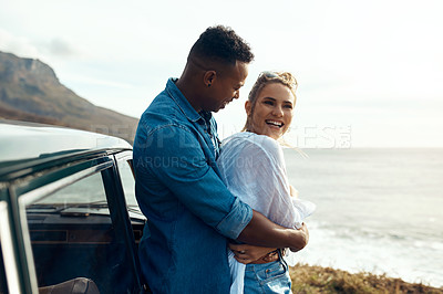 Buy stock photo Shot of a happy young couple sharing a romantic moment on a road trip along the coast