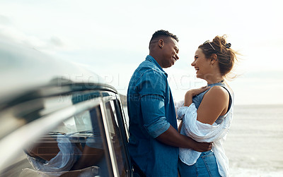 Buy stock photo Shot of a happy young couple sharing a romantic moment on a road trip along the coast