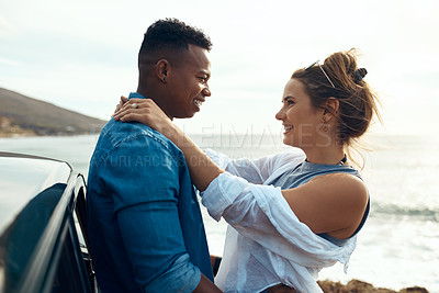 Buy stock photo Shot of a happy young couple sharing a romantic moment on a road trip along the coast