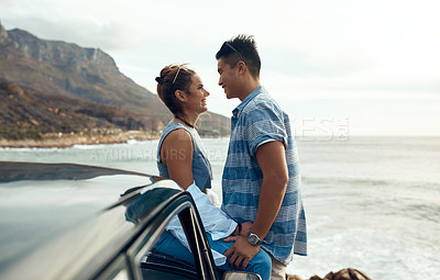 Buy stock photo Shot of a happy young couple sharing a romantic moment on a road trip along the coast