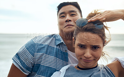 Buy stock photo Portrait of a happy young couple making funny faces on a vacation along the coast